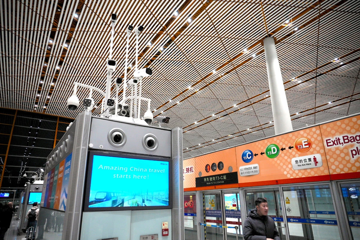 Surveillance cameras above a screen reading "Amazing China travel starts here!" monitor passengers at an airport in Beijing, China, on Dec. 21, 2024. (AP File Photo)