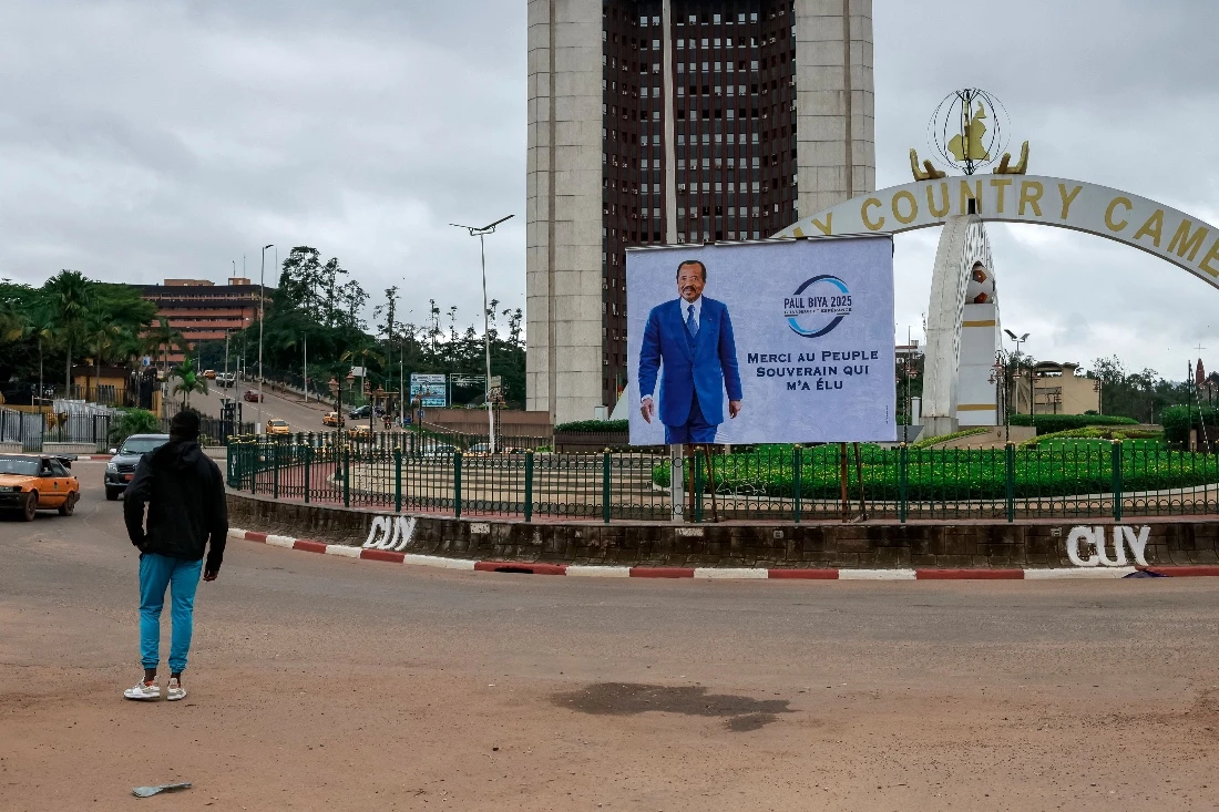 A pedestrian walks past a billboard of Cameroon's President Paul Biya reading: "I thank the sovereign people for electing me" on a street in Yaounde. (AFP)