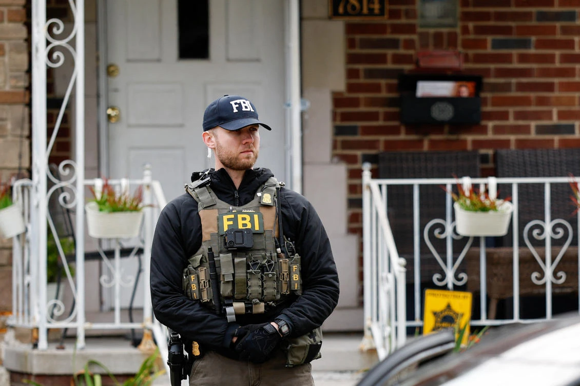 A member of the FBI Joint Terrorism Task Force stands watch in the front yard as law enforcement searches a home in Dearborn, Michigan, on Oct. 31, 2025. (AFP)