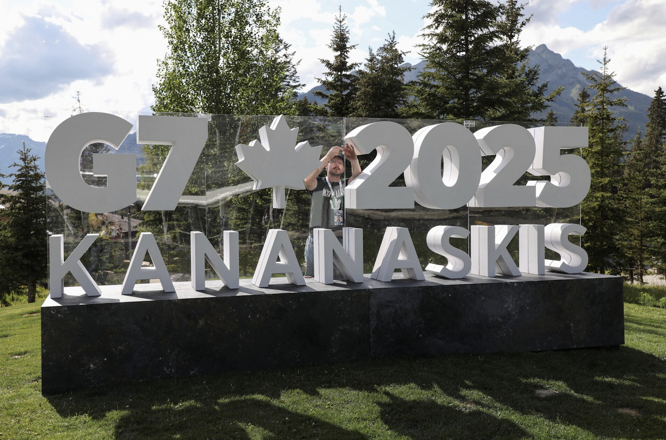 A worker prepares a sign ahead of the G7 summit at a satellite location in Banff, Alberta, Canada, June 14, 2025. (Reuters)