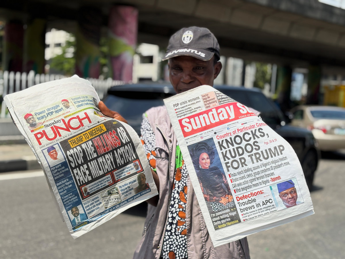 A vendor sells local newspapers with headlines referring to US President Donald Trump's comments about Nigeria, on the street of Lagos, Nigeria, on Nov. 2, 2025. (AP Photo/Sunday Alamba)