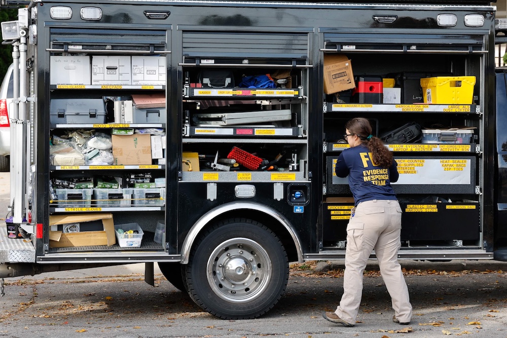 A member of the FBI Evidence Response Team works at an FBI vehicle as federal agents search a nearby home in Dearborn, Michigan, on Oct. 31, 2025. (AFP)