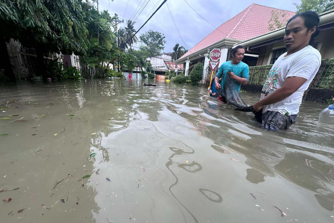 Men use a net as they try to catch fish from a nearby fish farm which overflowed due to floodwaters caused by Typhoon Kalmaegi as it affects Cebu City on Nov. 4, 2025. (AP)