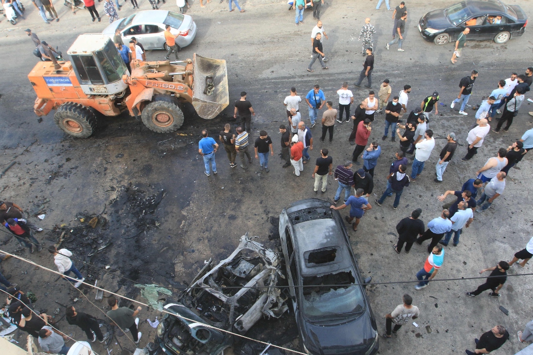 People gather at the site of an Israeli drone strike that targeted a vehicle in the southern Lebanese village of Ad Douwayr, near the city of Nabatieh. (AFP)