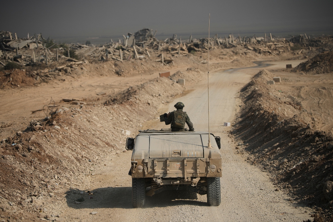 Israeli security forces drive past the ruins of buildings destroyed during Israeli ground and air operations in the Shijaiya neighborhood of Gaza City. (AP)