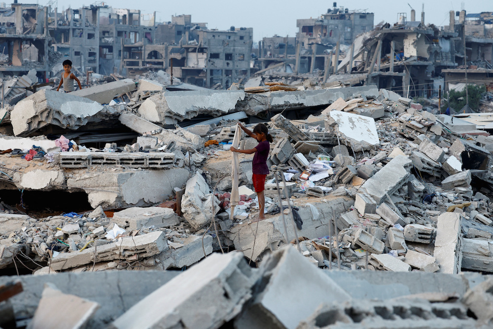 Palestinians stand on the rubble of destroyed buildings, amid a ceasefire between Israel and Hamas, in Jabalia, northern Gaza Strip, November 6, 2025. (Reuters)