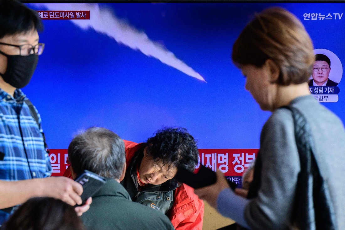 People walk past a television showing a news broadcast with file footage of a North Korean missile test, at a railway station in Seoul, South Korea. (AFP)
