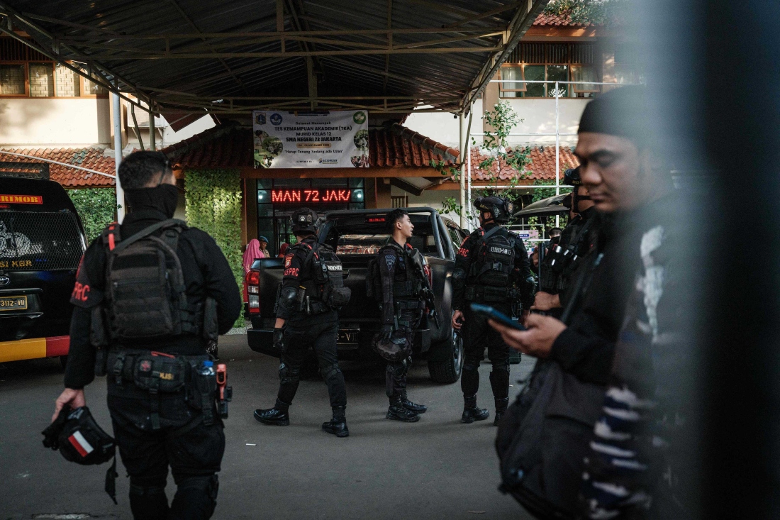 Police officers gather at the entrance of a school in Jakarta on Nov. 7, 2025. (AFP)