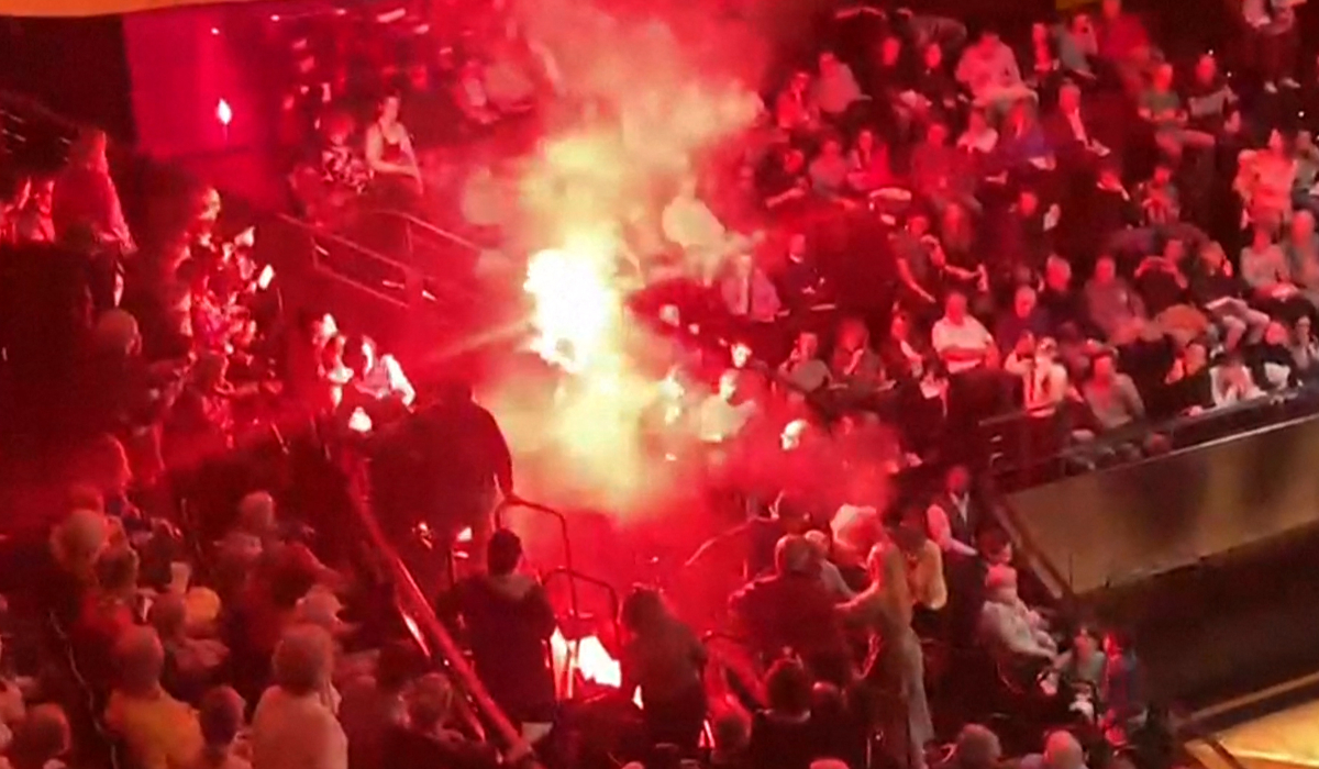 This framegrab taken from a UGC video shows incidents in the Pierre-Boulez Hall of the Philharmonie de Paris concert hall, where a person ignites a smoke bomb during a concert by the Israel Philharmonic Orchestra, on November 6, 2025 in Paris. (AFP)