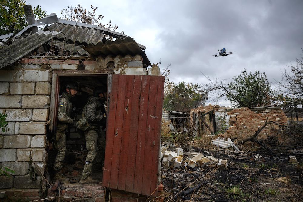 Above, Ukrainian infantry recruits protect against a simulated drone attack as they undergo a basic training course at an undisclosed location in eastern Ukraine on Oct. 11, 2025. (AFP)