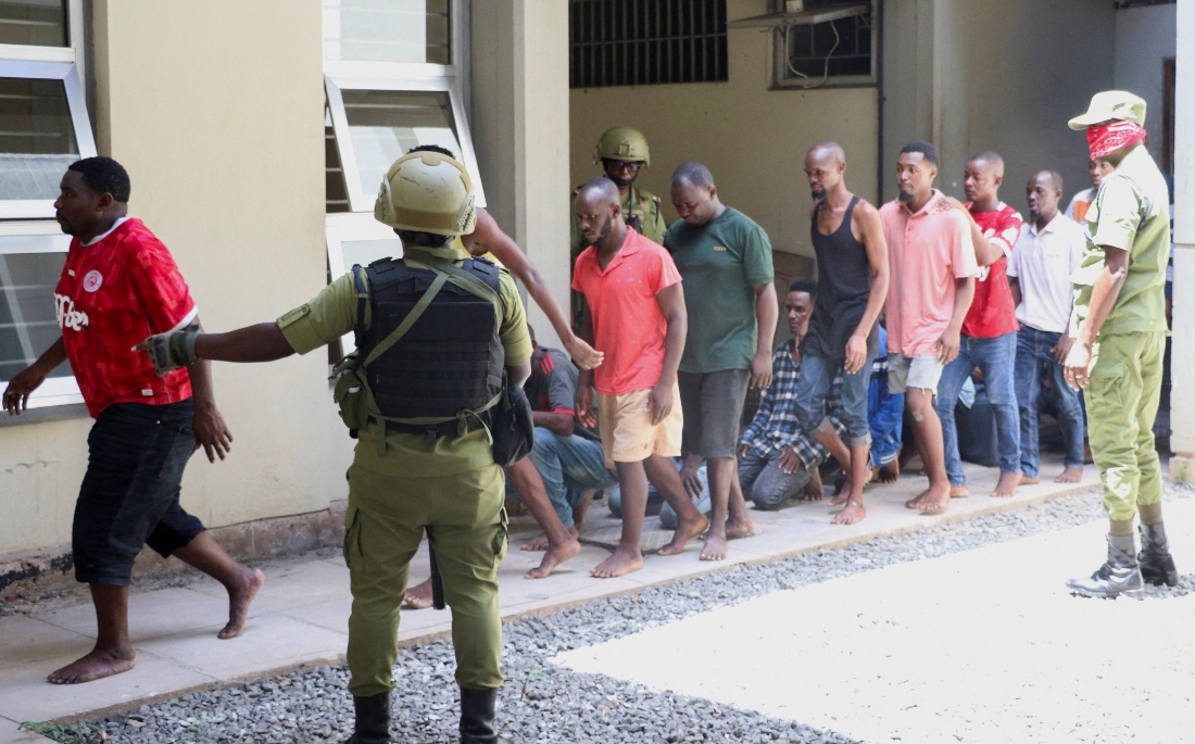 Tanzanians charged with treason for alleged involvement in violent protests that broke out during last week's presidential and parliamentary elections, walk in a formation as they arrive at the Kisutu Resident Magistrate's Court in Dar es Salaam, Tanzania. (Reuters)