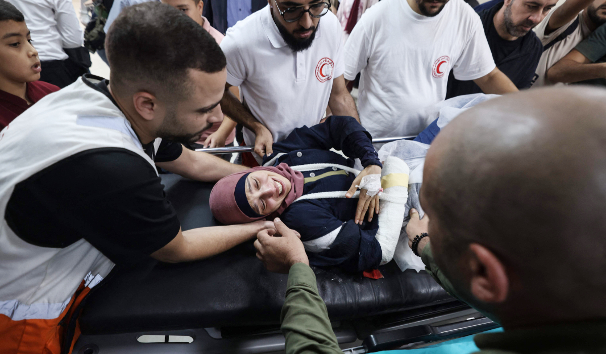 Palestinian photographer Raneen Sawafta is carried on a stretcher at Rafidia Hospital in Nablus after being injured by Israeli settlers. (AFP)