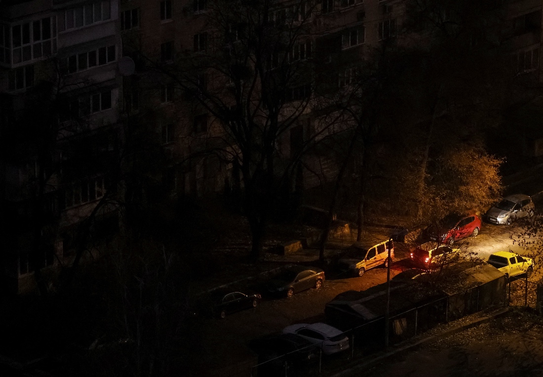 A car passes next to residential buildings during a power blackout after critical civil infrastructure was hit by Russian missile and drone attacks, amid Russia's attack on Ukraine, in Kyiv, Ukraine. (Reuters)