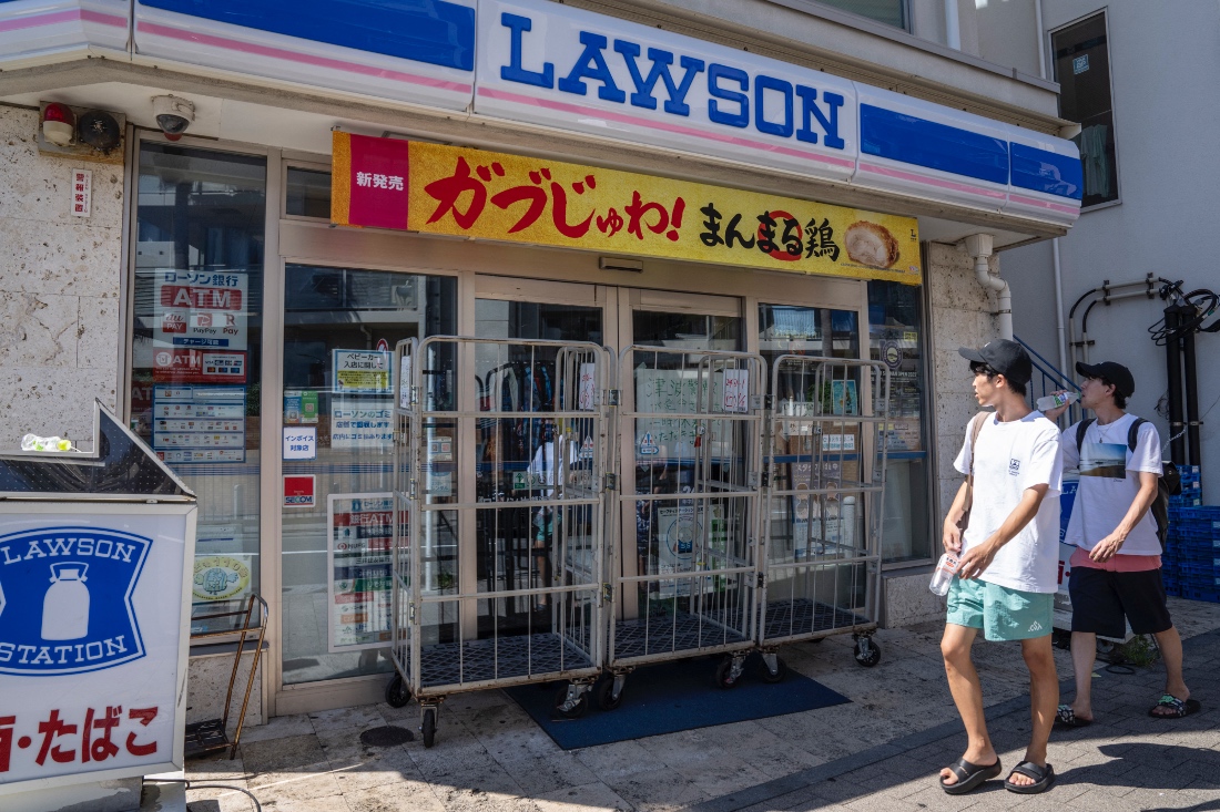 People walk past a convenience store which is closed due to a tsunami warning in Fujisawa city, Kanagawa prefecture on July 30, 2025. (AFP)