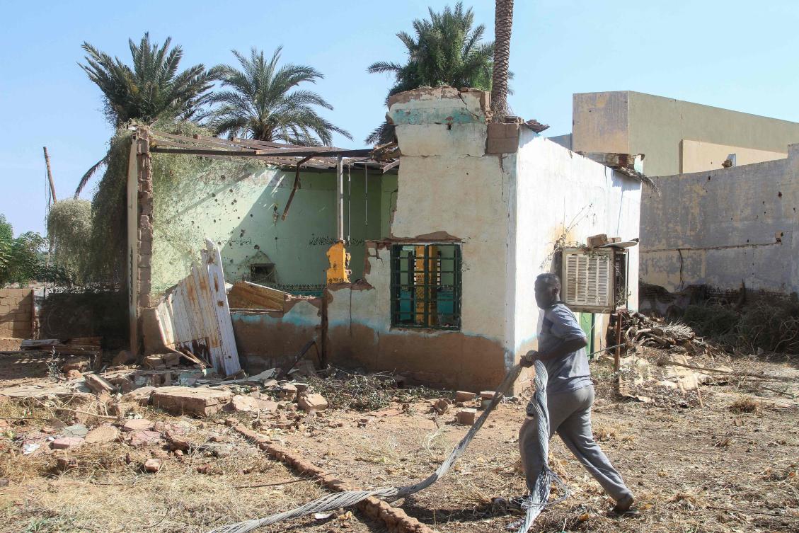 A man walks past a damaged building near the war-damaged National Theater of Omdurman, the twin-city of Sudan's capital, as Sudanese dramatists in collaboration with local authorities have launched an initiative to restore it, on November 7, 2025. (AFP)