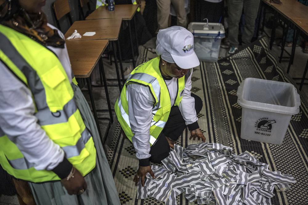 Tanzanian polling station officials spread the ballots at the beginning of the counting operations in Stone Town on Oct. 29, 2025. (AFP)
