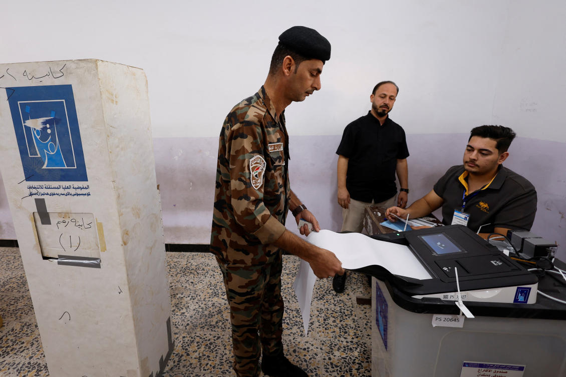An Iraqi security member votes at a polling station during special voting, two days before the polls open to the public in a parliamentary election, in Najaf, Iraq November 9, 2025. (REUTERS)
