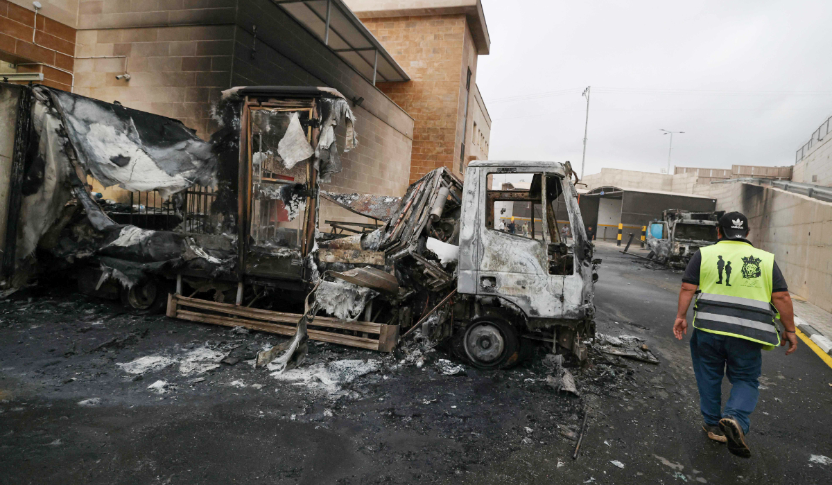 A Palestinian man inspects a burnt truck after an Israeli settlers attack in the village of Beit Lid, east of Tulkarm in the occupied West Bank on November 11, 2025. (AFP)