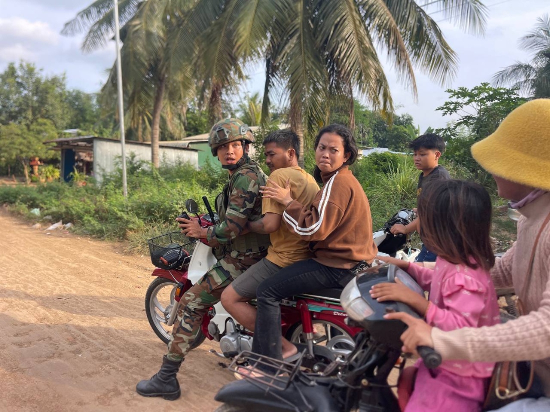 A photo shows an injured man, second from right, is picked up by a Cambodian army soldier on a motorbike after Thai soldiers opened fire on civilians in Prey Chan village, Banteay Meanchey province, on the border with Thailand. (AP)