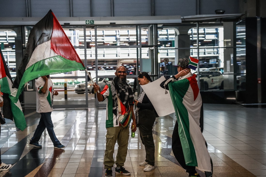 Pro Palestinian supporters wave a flag as they wait for the arrival of South African activists at OR Tambo International Airport in Kempton Park. (AFP)