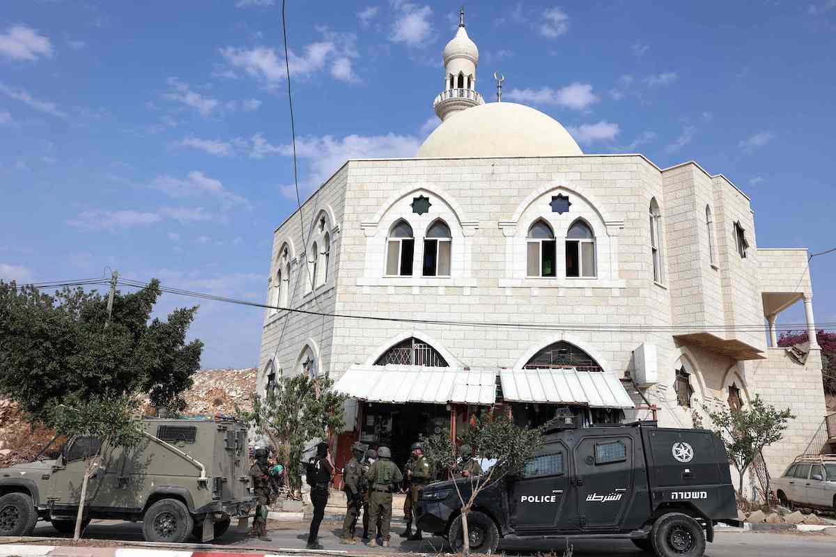 Israeli security forces at the Hajja Hamida Mosque after it was attacked by Israeli settlers. Saudi Arabia condemned the attack, along with other Israeli and settler violations. (AFP)