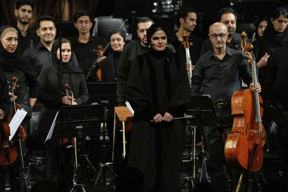 Iranian conductor and composer Paniz Faryousefi, center, and members of the Tehran Symphony Orchestra stand prior to their performance at Unity Hall in Tehran, Iran, Wednesday, Nov. 12, 2025. (AP Photo/Vahid Salemi)