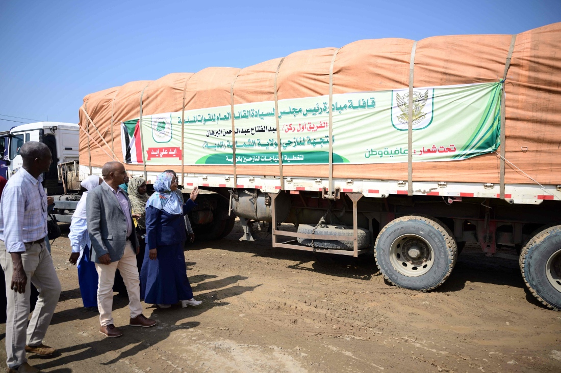 Sudan's officials inspect trucks loaded with aid in Port Sudan during the launch of a humanitarian aid convoy heading to the northern town of Al-Dabba. (AFP)