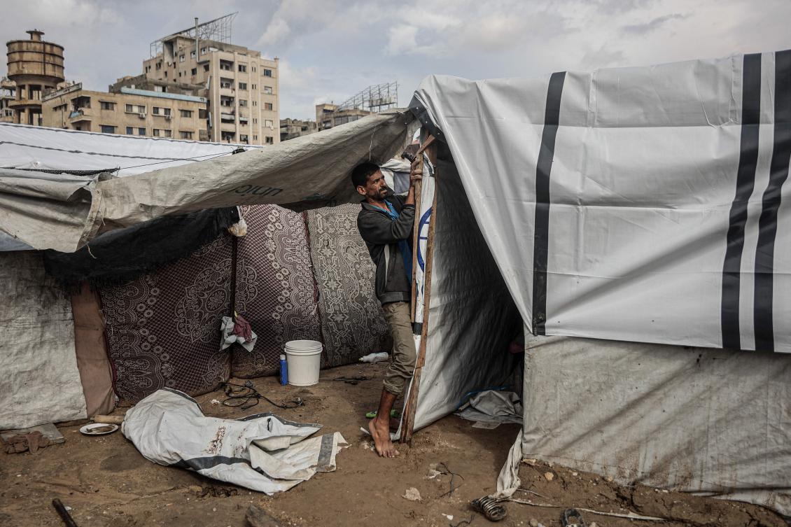 Above, a Palestinian man fixes his makeshift shelter as the first winter rains fall on a displacement camp in Gaza City on Nov. 14, 2025. (AFP)