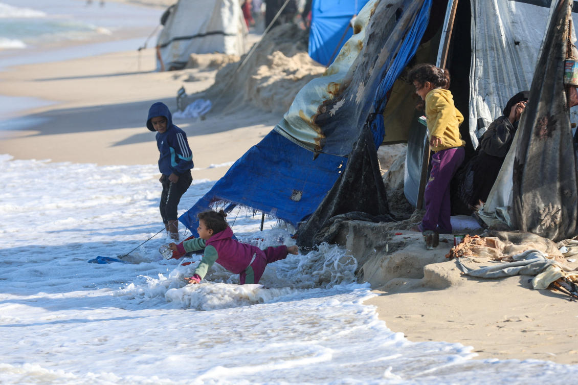 A child falls into the sea water, as Palestinians take shelter in their tents, amid a ceasefire between Israel and Hamas, in Khan Younis, southern Gaza Strip, Nov. 15, 2025. (Reuters)