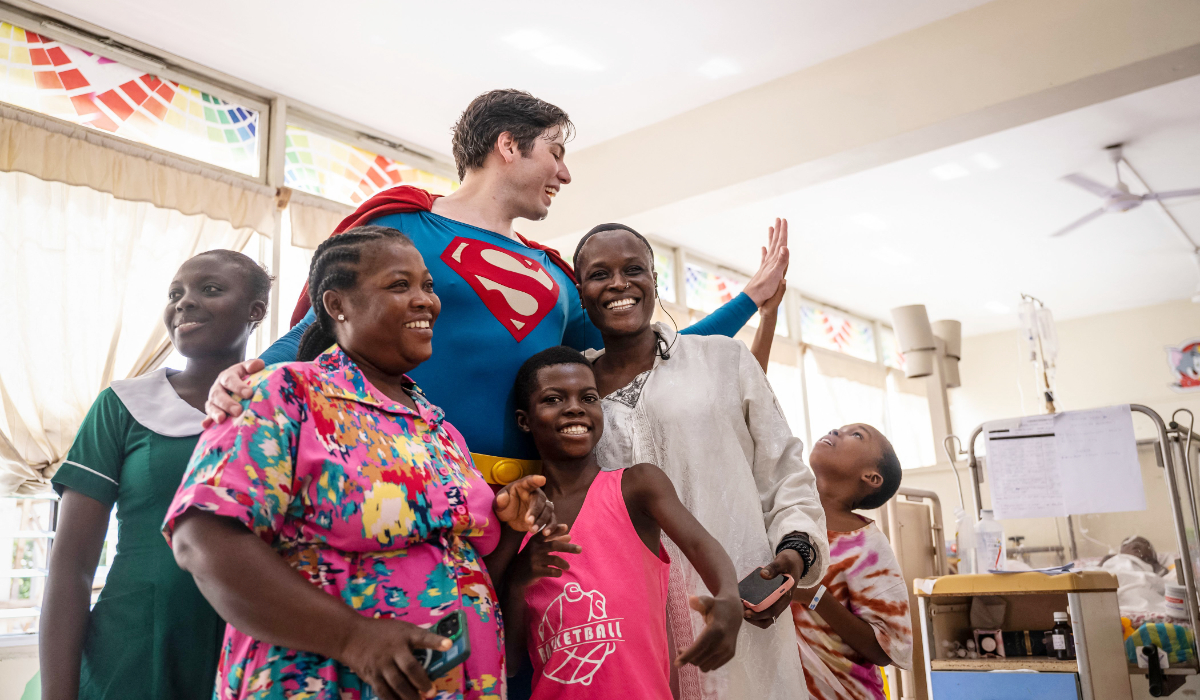 Leonardo Muylaert, known as the Brazilian Superman, poses with patients and their relatives during a visit at the Korle Bu Teaching Hospital in Accra, on November 14, 2025. (AFP)