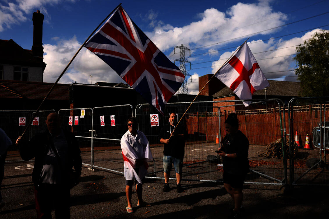 Protesters hold the Union Jack and St George's flags outside the Bell Hotel in Essex after the British government challenged a court ruling requiring asylum seekers to be temporarily evicted from the hotel in Epping, UK, on August 29, 2025. (REUTERS/File Photo)