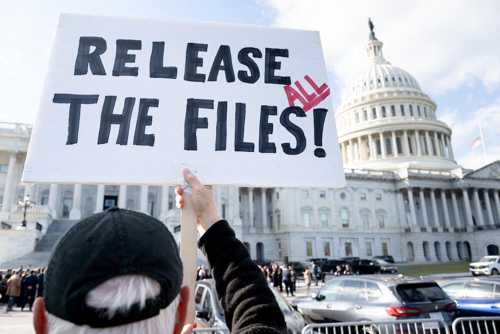 A protester holds a sign related to the release of the Jeffrey Epstein case files outside the US Capitol in Washington, DC on Nov. 12, 2025. (AFP)