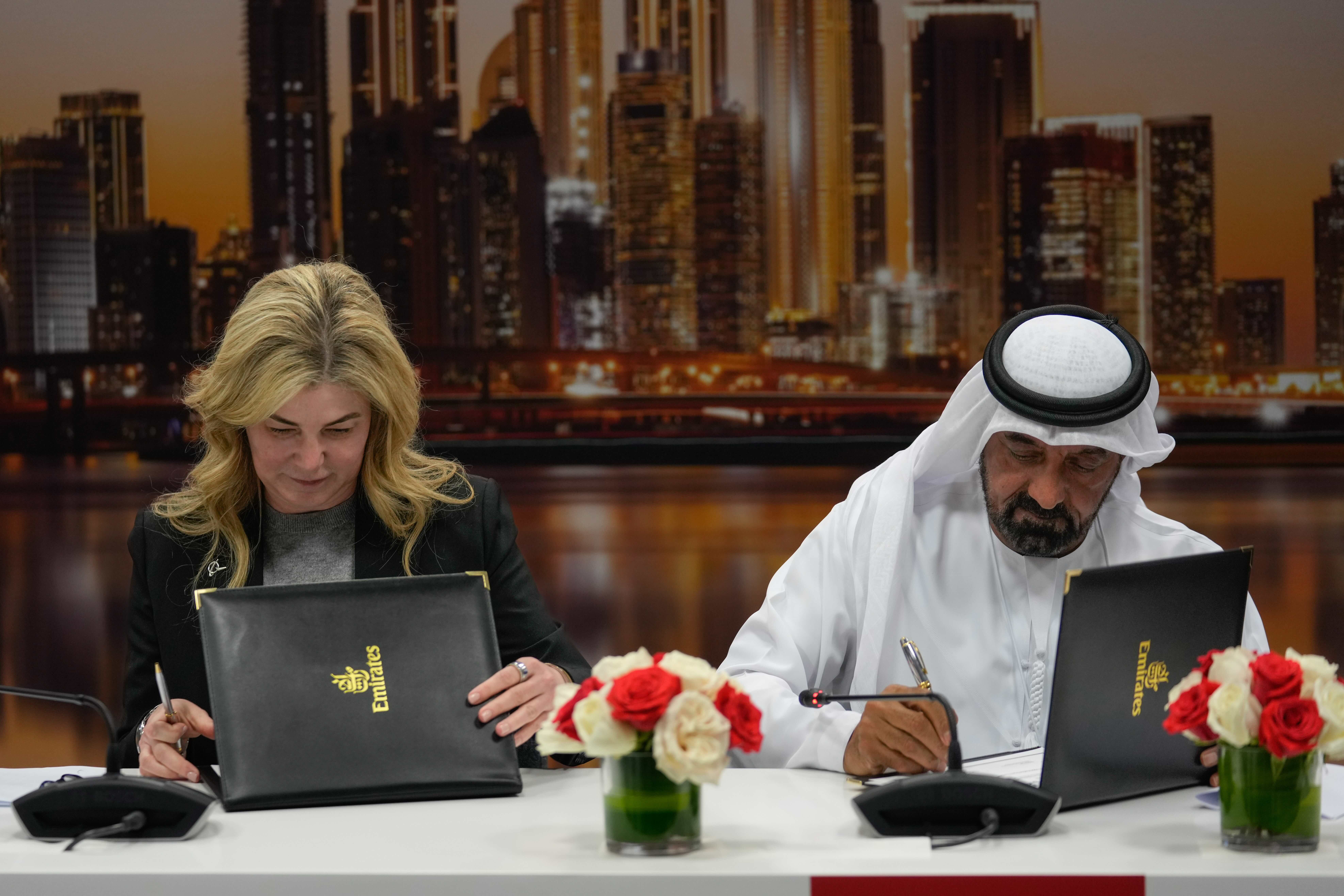 Stephanie Pope, president and CEO of Boeing Commercial Airplanes, left, and Sheikh Ahmed bin Saeed Al-Maktoum, president, Dubai Civil Aviation Authority and chairman of Emirates airlines, sign an agreement to order 65 additional Boeing 777X aircrafts, during a press conference on the opening day of the Dubai Air Show on Monday. AP