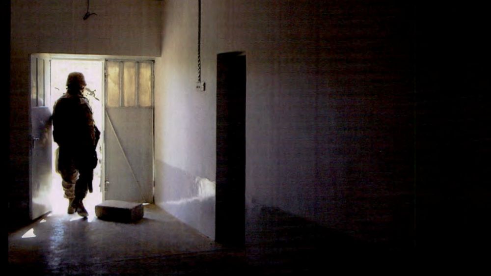 A US marine walks out of a home in Haditha, Iraq, after multiple civilians were killed in November 2005. (NCIS)