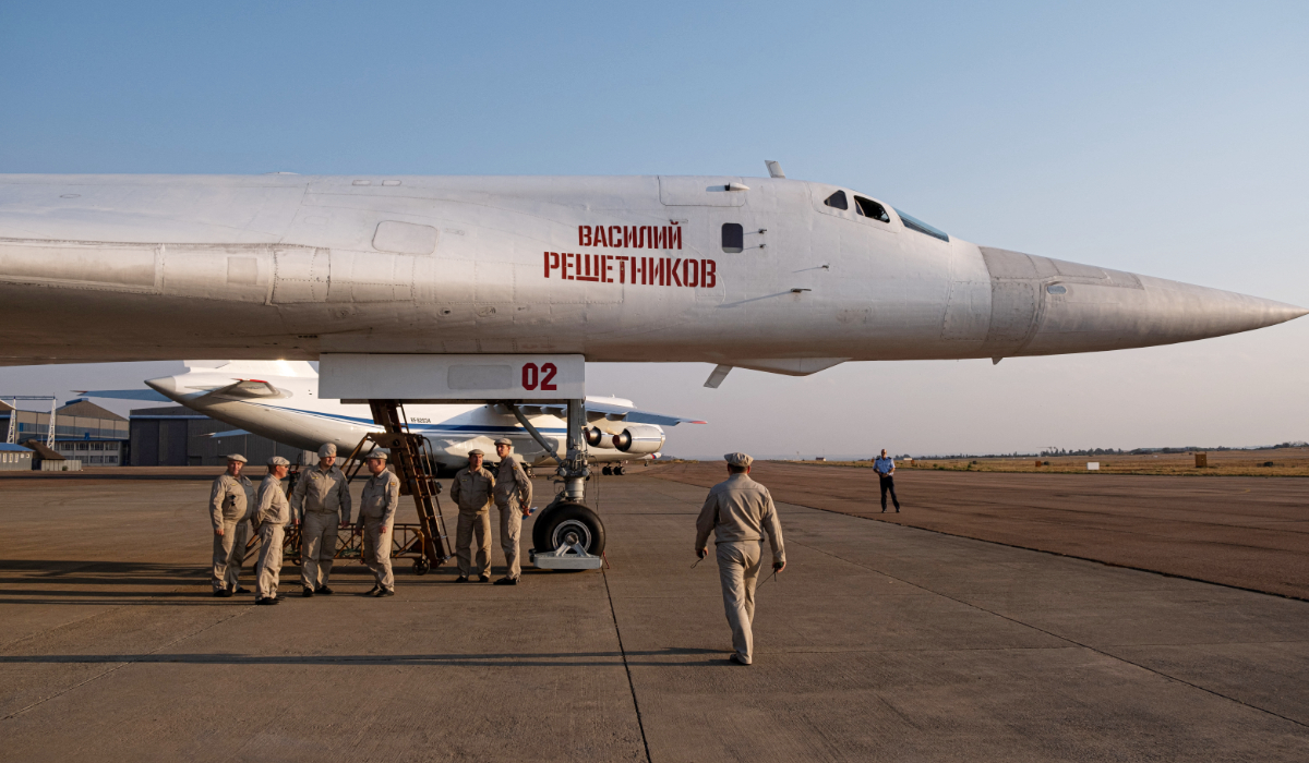 Military personnel gather under a Russian Air Force Tupolev Tu-160 "Blackjack", a supersonic variable-sweep wing heavy strategic bomber, is parked on the tarmac at the Waterkloof Air force Base in Centurion, south of Pretoria, northeastern South Africa. (AFP file photo)