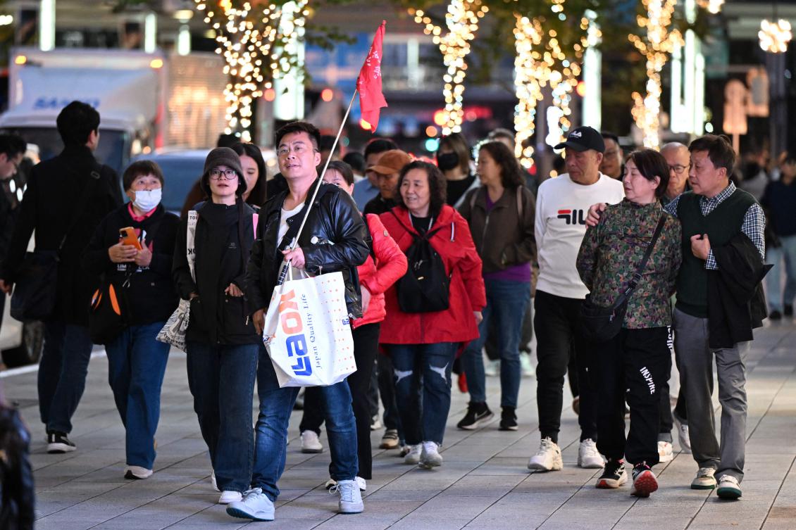 Above, a Chinese tour group walks in the Ginza shopping district in Tokyo on Nov. 17, 2025. China warned its citizens to avoid the tourist hotspot in a spat over Prime Minister Sanae Takaichi’s comments on Taiwan. (AFP)