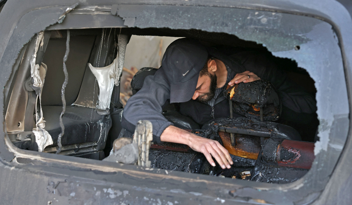A Palestinian man inspects a car that was damaged following an attack by Israeli settlers in Jabaa village near Bethlehem, in the occupied West Bank on November 18, 2025. (AFP)