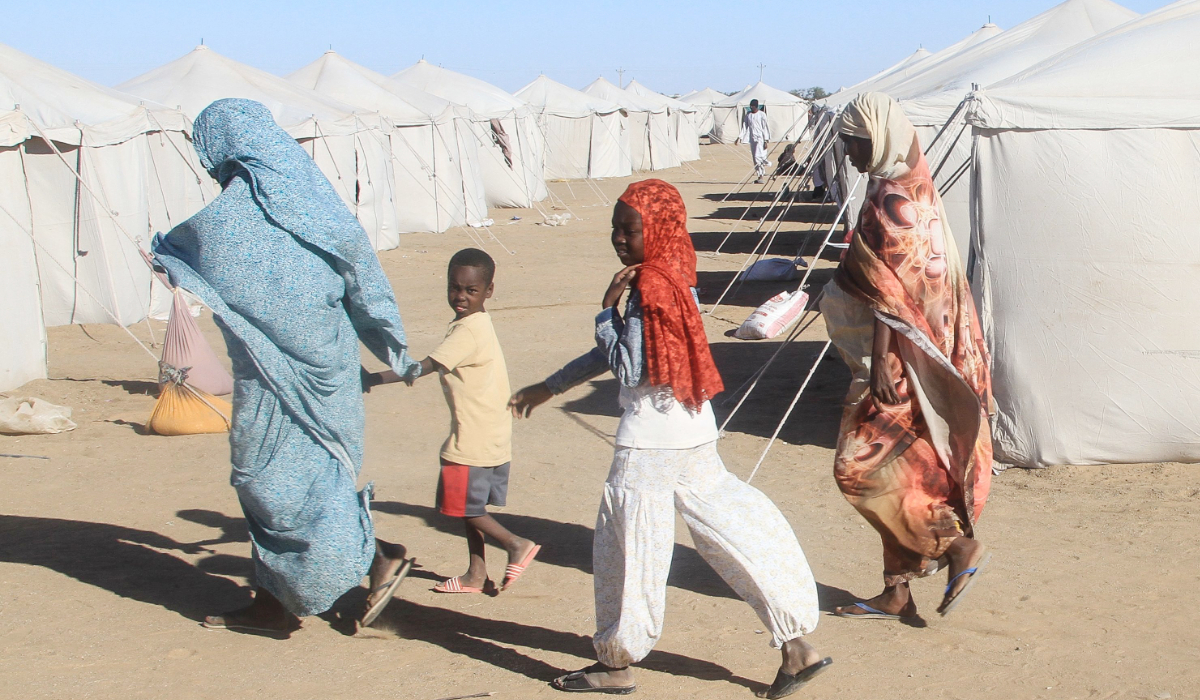 udanese who fled El-Fasher walk past tents at the Al-Afad camp for displaced people in the town of Al-Dabba, northern Sudan, on November 15, 2025. (AFP)