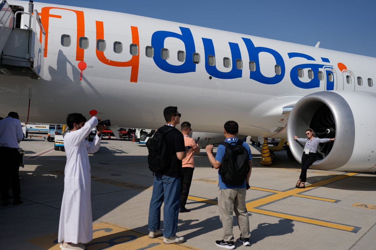 Visitors take photos by a FlyDubai Boeing 737 MAX 8 plane at the Dubai Air Show, United Arab Emirates, Wednesday, Nov. 19, 2025. (AP Photo/Altaf Qadri)