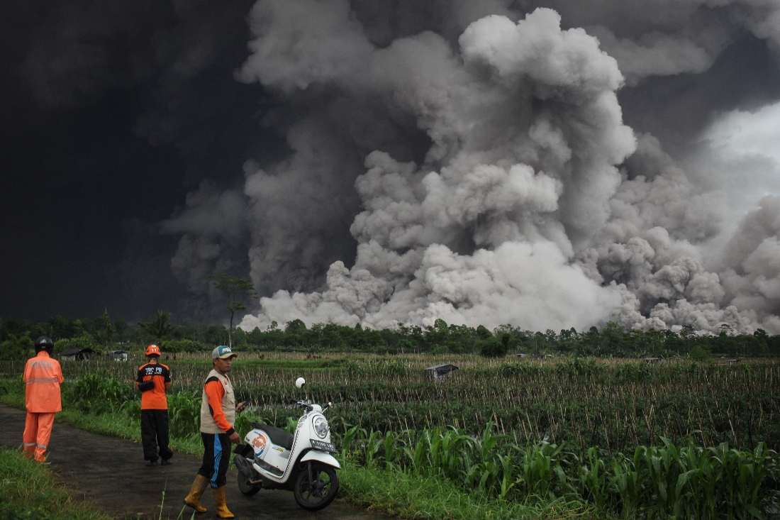 People look at a pyroclastic flow during the eruption of Mount Semeru in Lumajang, East Java, Indonesia. (AFP)