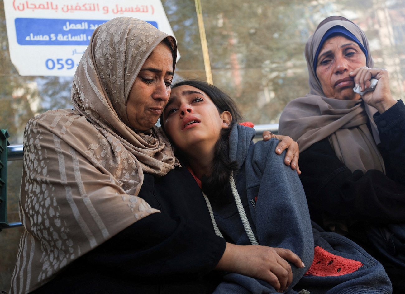 Mourners react as they attend the funeral of Palestinians who were killed in overnight Israeli strikes, at Al-Shifa Hospital in Gaza City, November 20, 2025. (Reuters)
