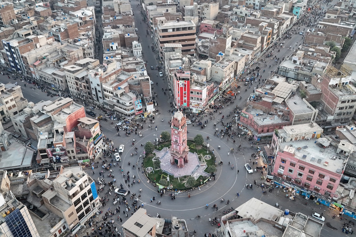 An aerial view shows commuters driving through a clock tower (C), formerly known as the Lyallpur Clock Tower, in Faisalabad in Pakistan's Punjab province on November 7, 2025. (FILE/AFP)