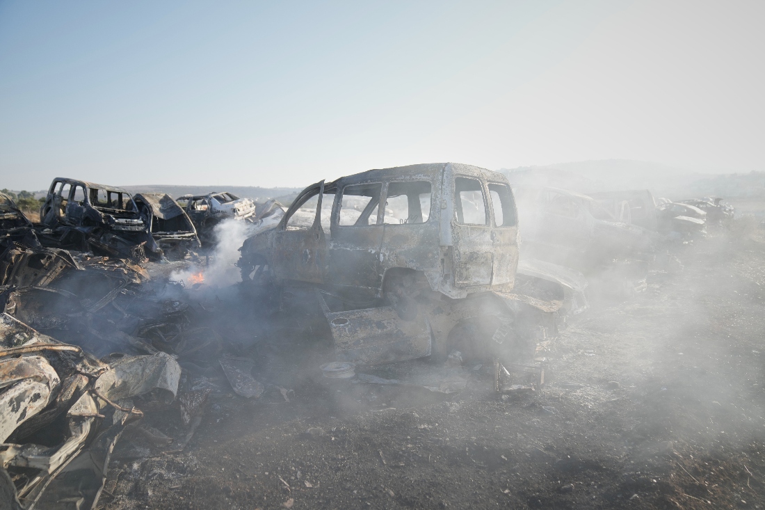 Smoke rises from scorched cars in a scrapyard that Israeli settlers set ablaze the night before, in the town of Hawara near the West Bank city of Nablus. (AP)