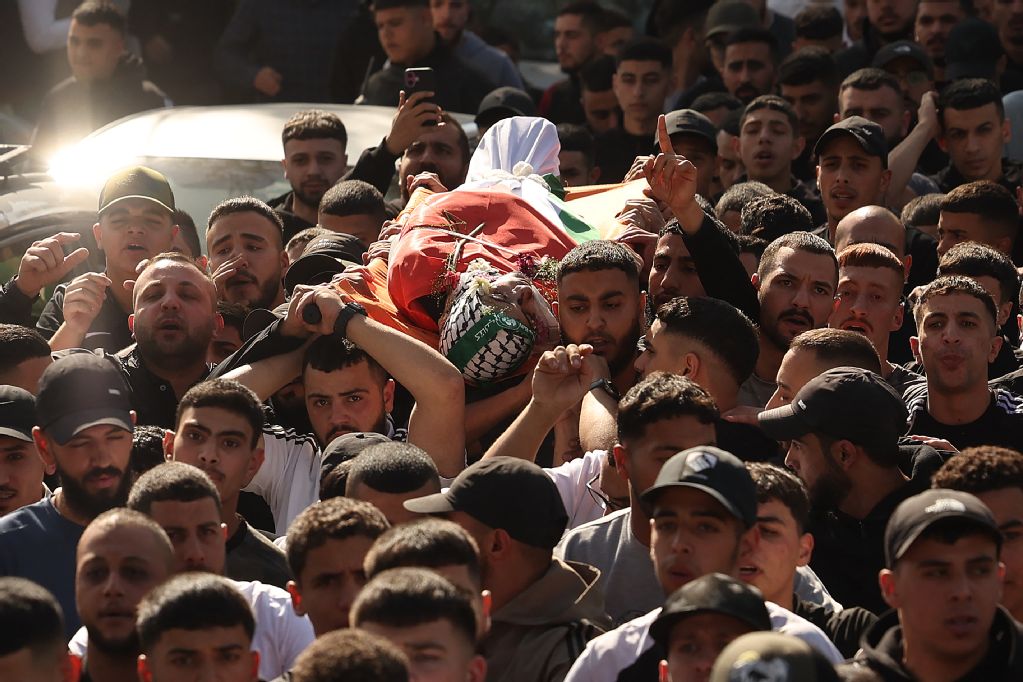 Mourners carry the body of 18-year-old Palestinian Amr Khaled Al-Marboua during his funeral in Al-Amari refugee camp near Ramallah on Friday. The teenager was killed by Israeli forces. (AFP)