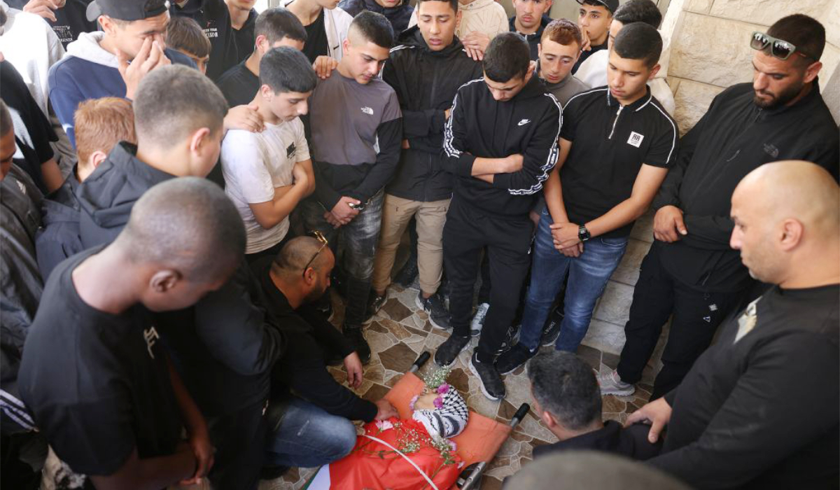 Mourners gather around the body of 16-year-old Palestinian Sami Mashayekh during his funeral in Kafr Aqab near Ramallah in the West Bank. (AFP)