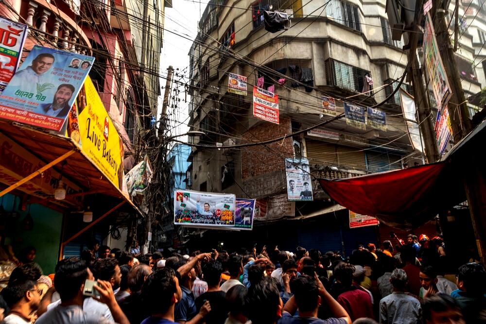 People gather outside a narrow lane in old city area where a roof and wall collapsed, after an earthquake in Dhaka, Bangladesh on Nov. 21, 2025. (AP)