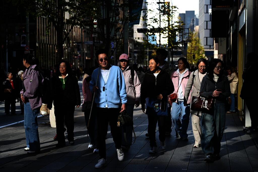 Above, tourists from China walk on a street in the Ginza shopping district in Tokyo on Nov. 22, 2025. (AFP)