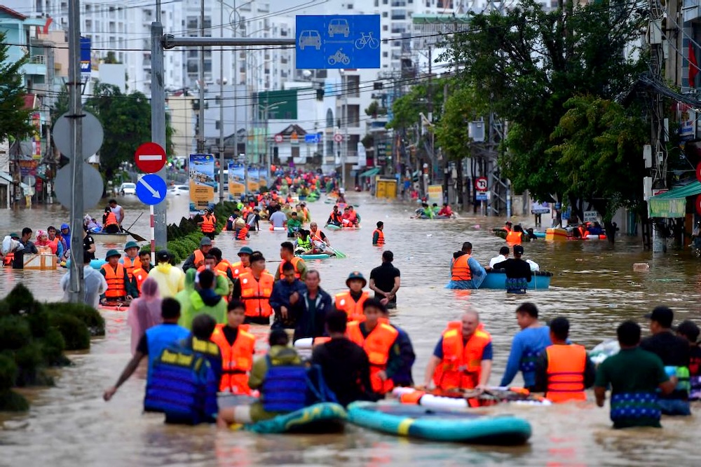 Above, residents wade through floodwaters in Nha Trang in Vietnam’s coastal province of Khanh Hoa. Whole sections of coastal Nha Trang city were inundated last week, while deadly landslides struck highland passes around the Da Lat tourist hub. (AFP)