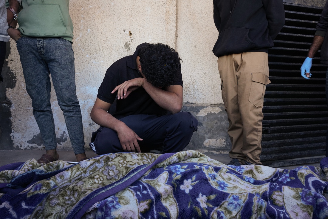 Ahmed Al-Bohisi mourns over the body of his cousin, Mohammad Abu Shawish, 18, who was killed in an Israeli military strike, during his funeral at Al-Aqsa Hospital in Deir al-Balah in the Gaza Strip. (AP)