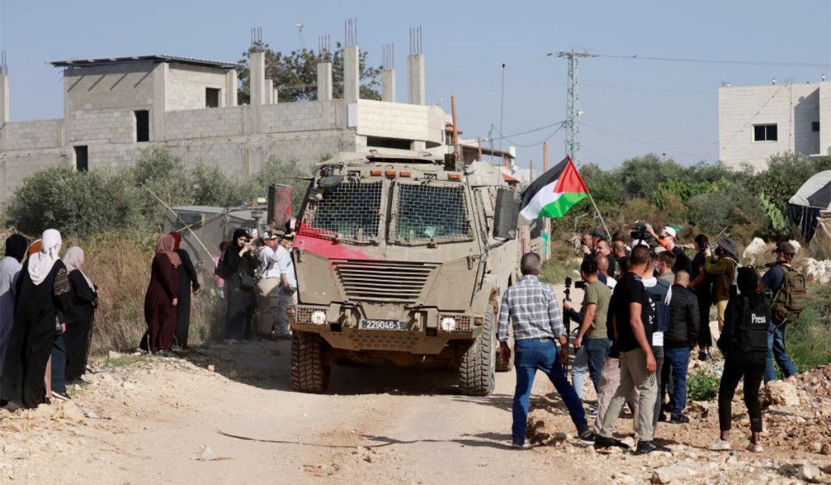 Residents of the Nur Shams refugee camp, near Tulkarem in the Israeli-occupied West Bank, and foreign solidarity activists gather at the entrance of the camp during a protest demanding the right to return to their homes, on November 23, 2025. (AFP)